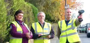Photo of three volunteers checking vehicle speeds